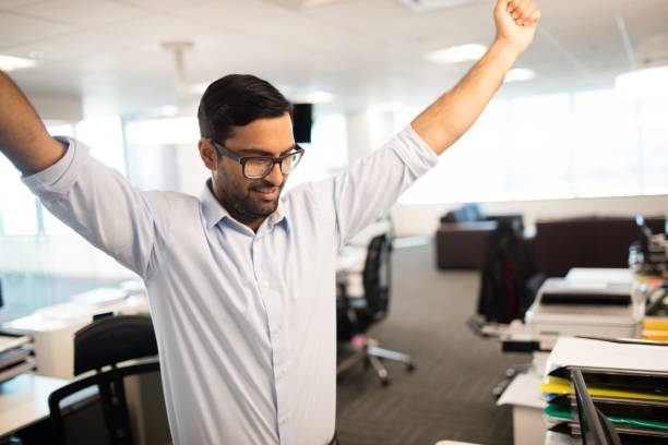 istock Happy businessman with arms raised at office 676020150