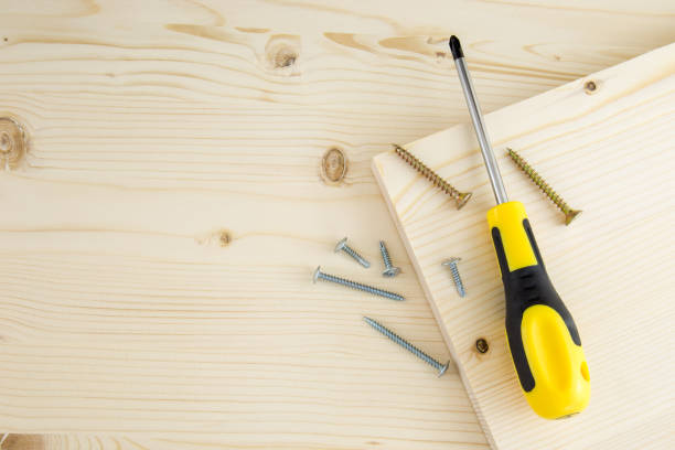 istock Screwdriver and screws on a fresh wood board background 676023040