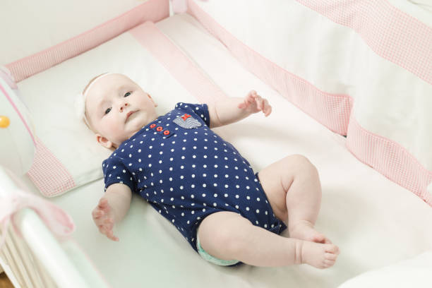 istock Infant lies on her back in a baby crib. 676031058