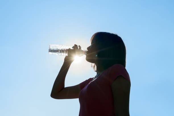 istock Female drinking water in hot summer - heat stroke concept. 676031146