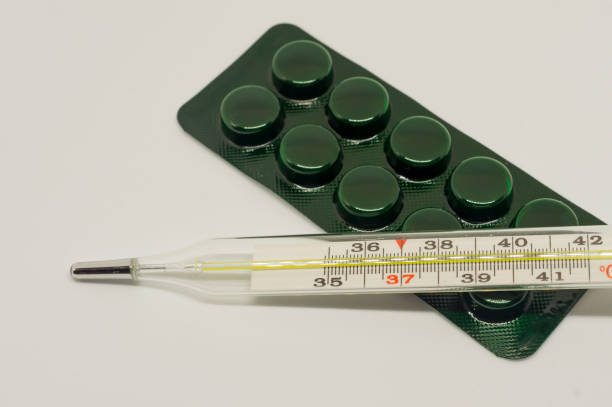 istock medicine pills and thermometer on white background 676034052