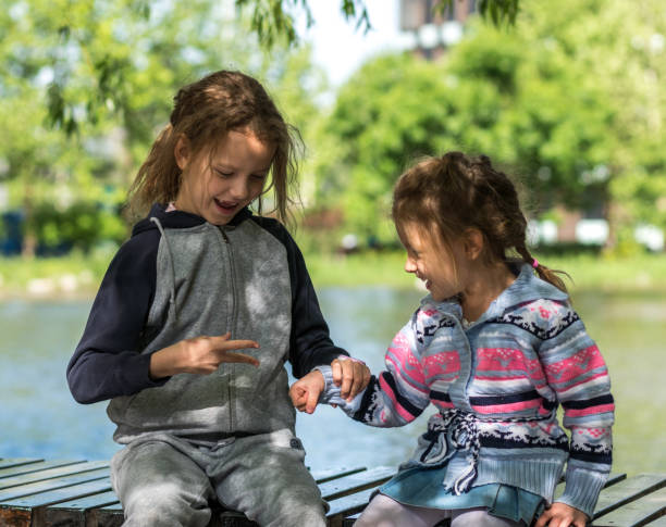 istock Girls (4-9 years) playing rock paper scissors, smiling, side view 676034736