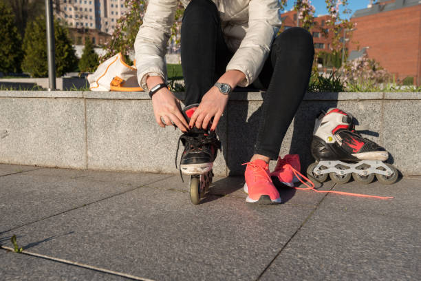 istock Girl puts on roller skates in the park 676053678