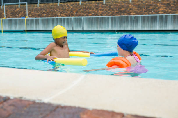 istock Two kids swimming in pool 676054382