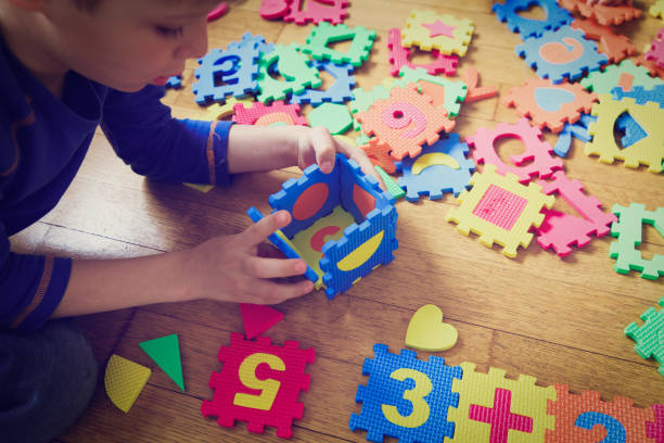 istock little boy playing with puzzle, education concept 676057262