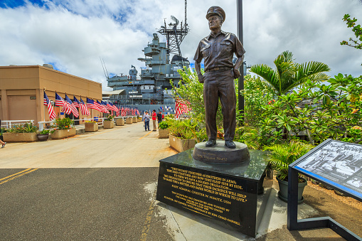 HONOLULU, OAHU, HAWAII, USA - AUGUST 21, 2016: statue of Admiral Chester W. Nimitz at battleship Missouri Pearl Harbor Memorial with American flags. Commander in chief of United States Pacific Fleet.