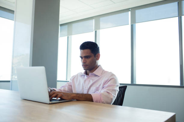 istock Serious businessman using laptop in conference room 676066566