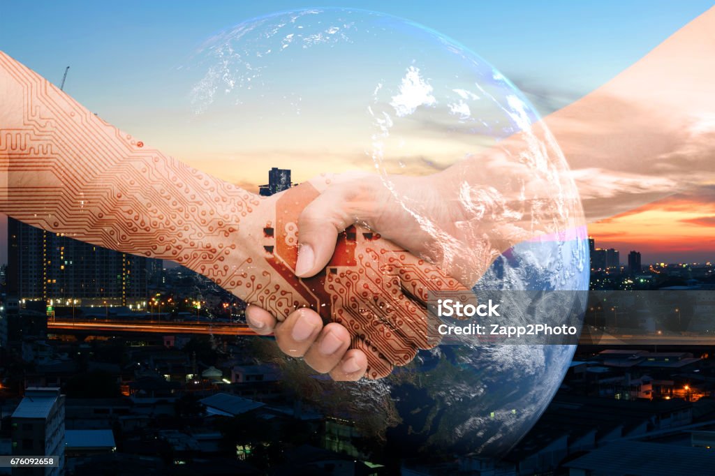 Industry 4.0 internet of things and digital disruption concept. Double exposure of Shaking hands of male people and robot circuit electronic hand with construction building and earth furnished by NASA Technology Stock Photo