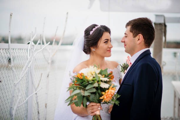 istock Wedding couple stay on the pier berth at cloudy day. 676093088