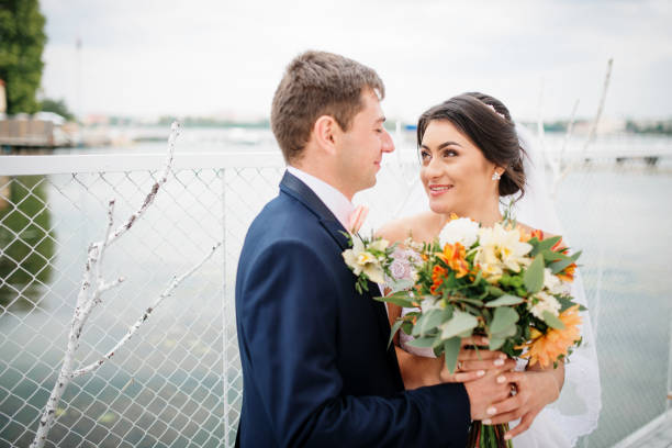 istock Wedding couple stay on the pier berth at cloudy day. 676093124