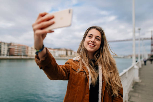 genç kadın bir selfie alarak - redes sociales stok fotoğraflar ve resimler