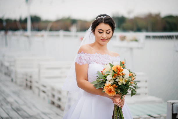 istock Brunette bride stay on the pier berth at cloudy day. 676093532