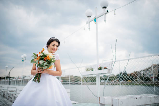 istock Brunette bride stay on the pier berth at cloudy day. 676094142