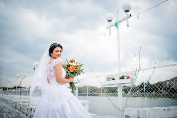 istock Brunette bride stay on the pier berth at cloudy day. 676094332