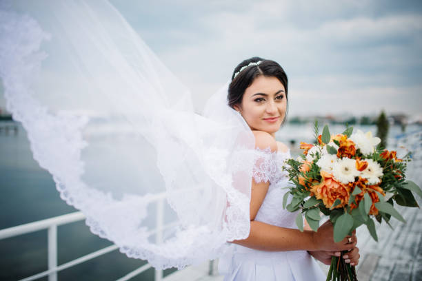istock Brunette bride stay on the pier berth at cloudy day. 676094398