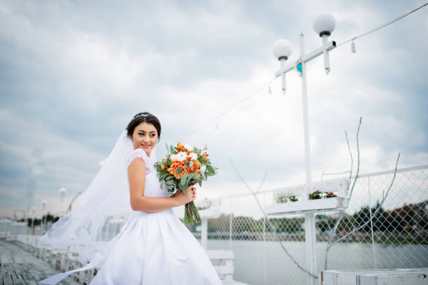 istock Brunette bride stay on the pier berth at cloudy day. 676094480