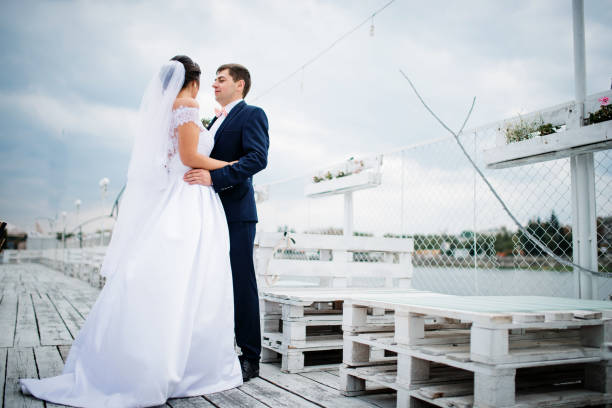 istock Wedding couple stay on the pier berth at cloudy day. 676094626