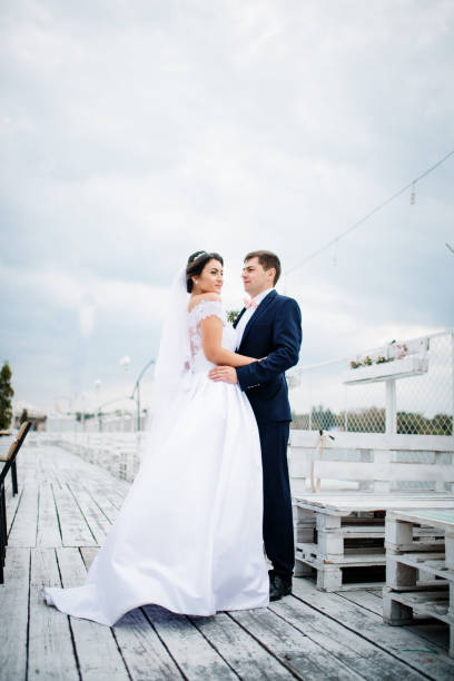 istock Wedding couple stay on the pier berth at cloudy day. 676094640