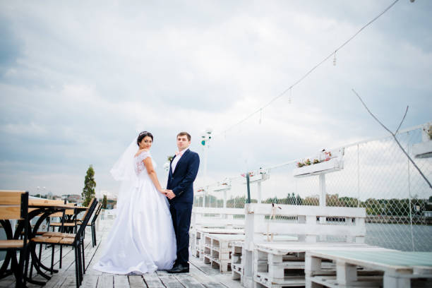 istock Wedding couple stay on the pier berth at cloudy day. 676094738