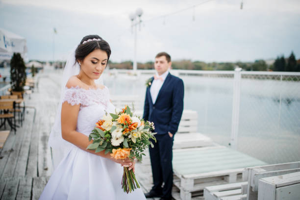 istock Wedding couple stay on the pier berth at cloudy day. 676095080
