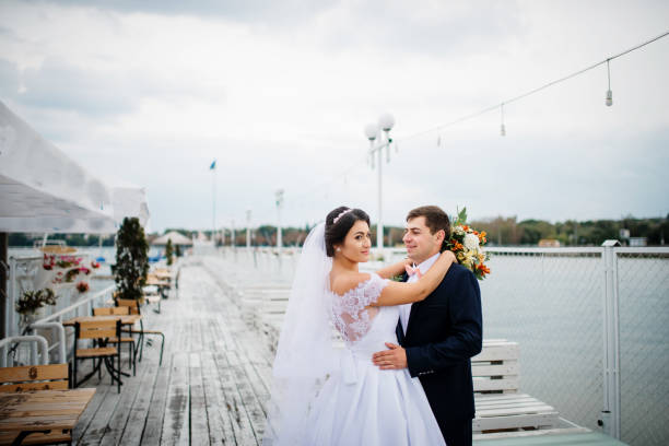 istock Wedding couple stay on the pier berth at cloudy day. 676095426