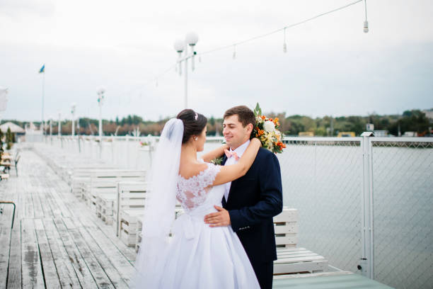 istock Wedding couple stay on the pier berth at cloudy day. 676095512