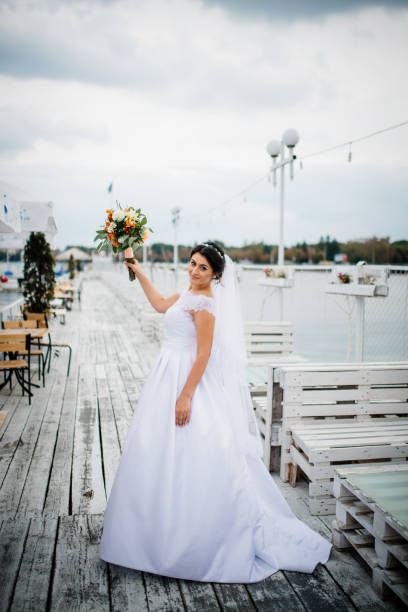 istock Brunette bride stay on the pier berth at cloudy day. 676095566