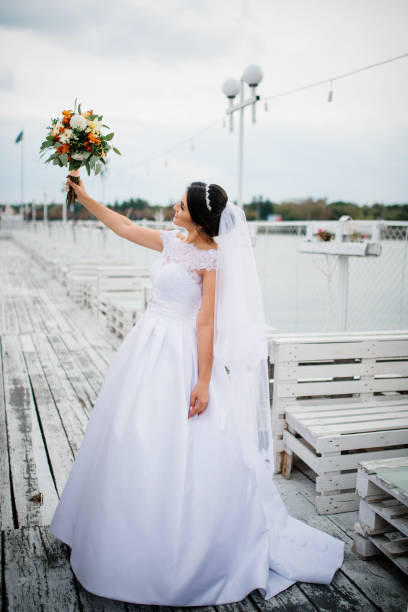 istock Brunette bride stay on the pier berth at cloudy day. 676095948
