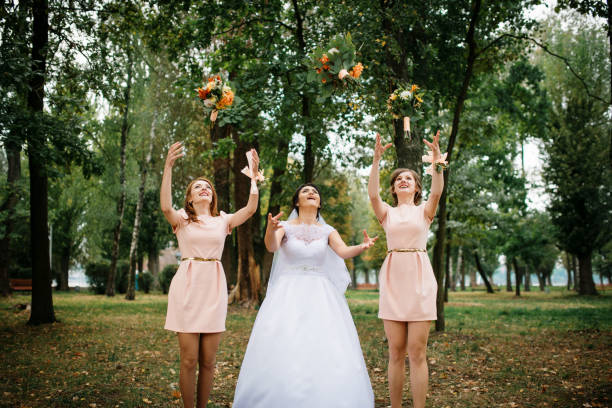 istock Bride with bridesmaids throw bouquet at wedding day. 676096258