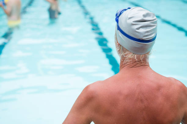 istock Senior man sitting at poolside 676139138