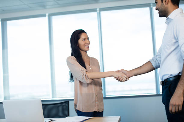 istock Smiling business people shaking hands during meeting at office 676139320