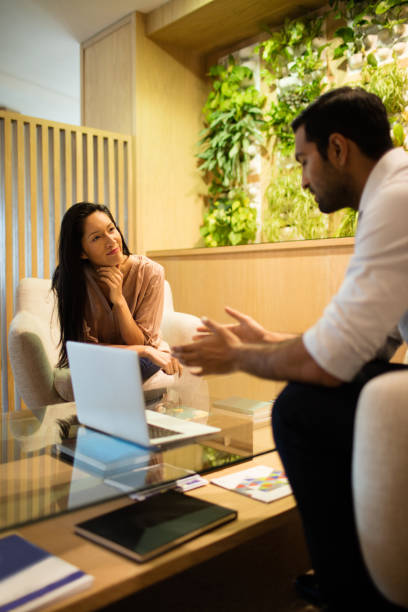 istock Business colleagues discussing while sitting on sofa by laptop on table 676150662