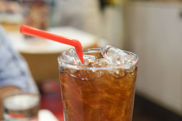 istock Soft Drink (cola) with ice and red straw, close up 676172830