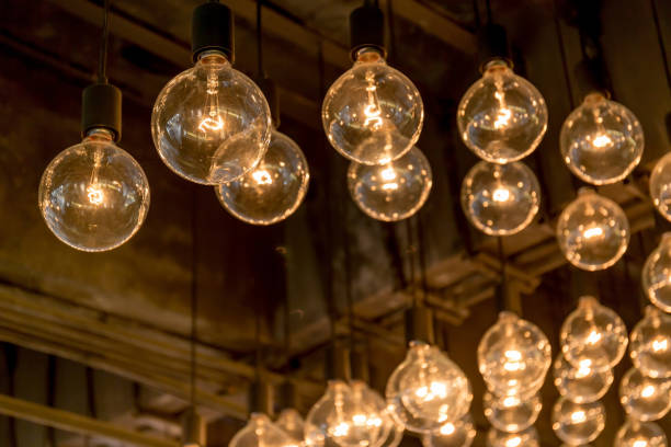 istock Group of Edison light bulbs hanged decoration from ceiling in department store. 676174778