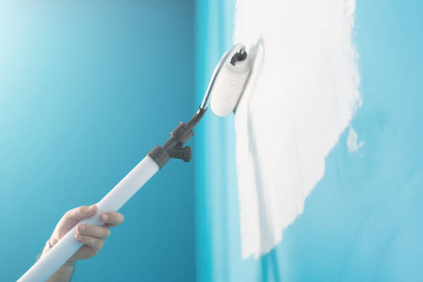 istock Young man painting wall with paint roller. Man at work concept 676197688