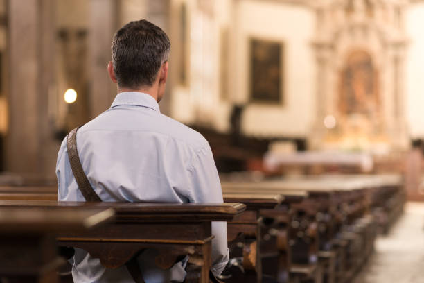 Man sitting at Church Man sitting in a pew at Church and meditating, faith and religion concept pew stock pictures, royalty-free photos & images