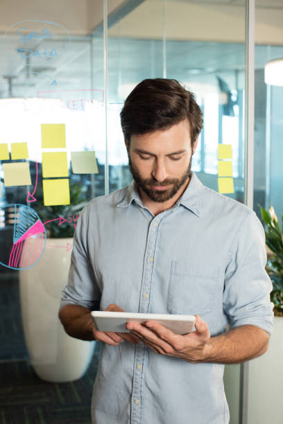 istock Businessman using digital tablet against strategy on glass 676236956