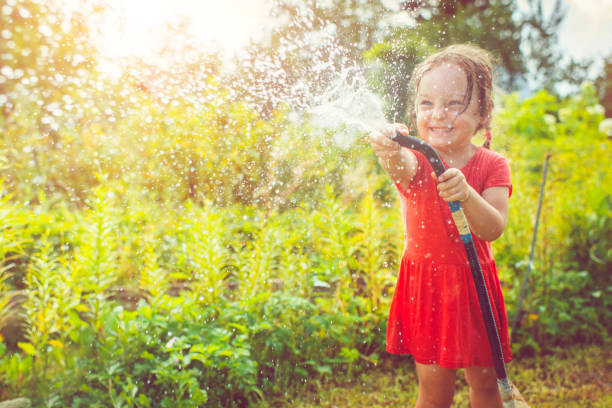 istock Happy girl playing with water in summer 676249508