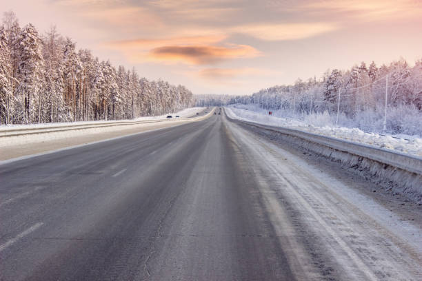 istock Road winter, evening hours, through the forest 676272040