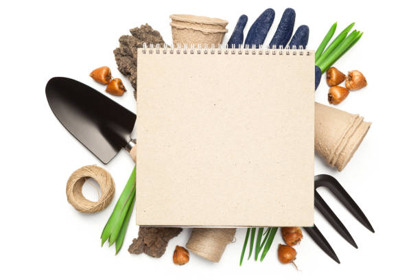 Gardening concept. Blank notebook over gardening tools isolated on white background. Copy space. Top view