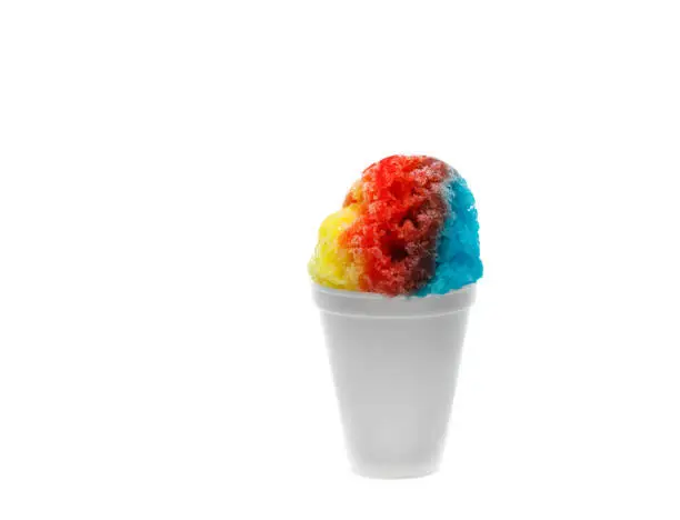 Photo of Rainbow Hawaiian Shave Ice or Snow Cone in a white disposable cup on a white background.