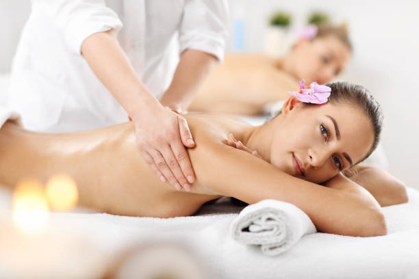 istock Two beautiful women getting massage in spa 676334352
