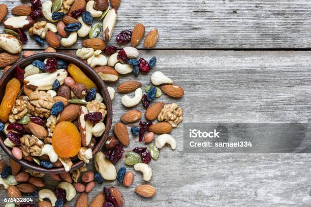 Nuts And Dried Fruits In A Bowl Over Rustic Wooden Table Stock Photo - Download Image Now