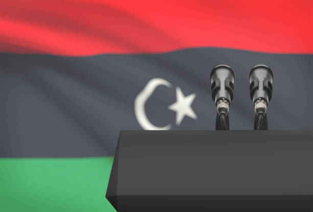 istock Pulpit and two microphones with a national flag on background - Libya 676446758
