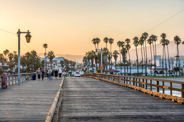 people at scenic old wooden pier in Santa Barbara in sunset Santa Barbara: people at scenic old wooden pier in Santa Barbara in sunset. The pier was completed in 1872 and was the longest pier at that time in the USA. santa barbara california photos stock pictures, royalty-free photos & images