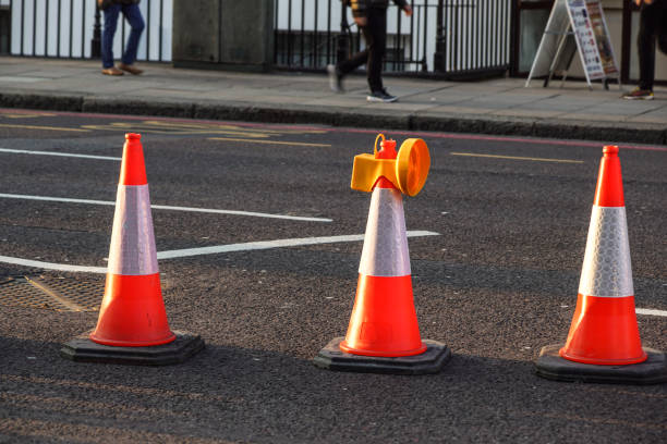 istock traffic cone, with white on gray asphalt, at roadwork 676542824
