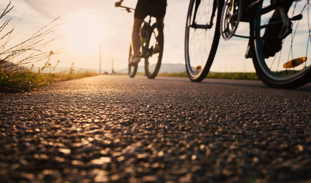 istock Bike wheels close up image on asphalt sunset road 676567976