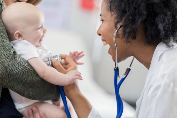 entzückende baby lächelt kinderarzt - doctor child baby healthcare and medicine stock-fotos und bilder