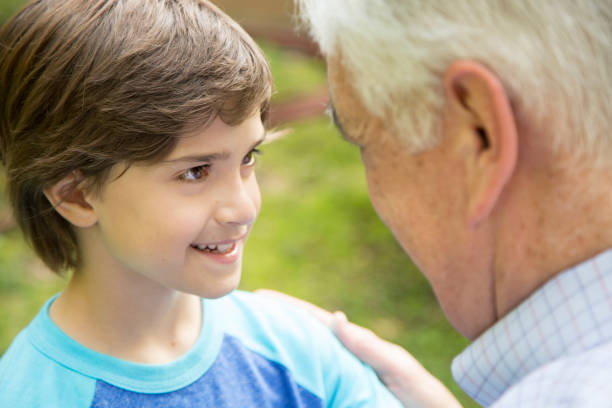 istock Grandfather and grandson face-to-face outdoors together. 676571300