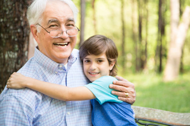 istock Grandfather and grandson hugging outdoors together. 676582040